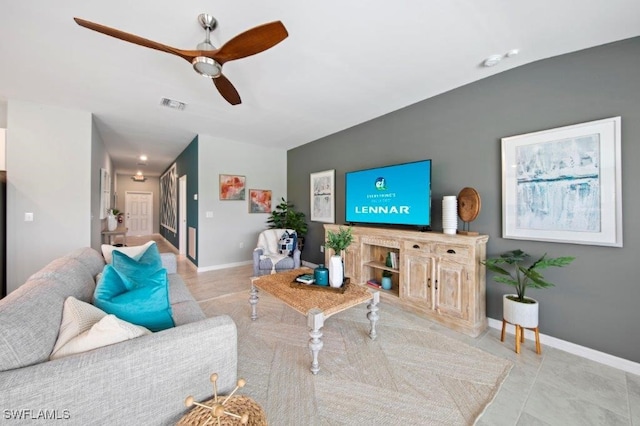 living area with light tile patterned floors, a ceiling fan, visible vents, and baseboards