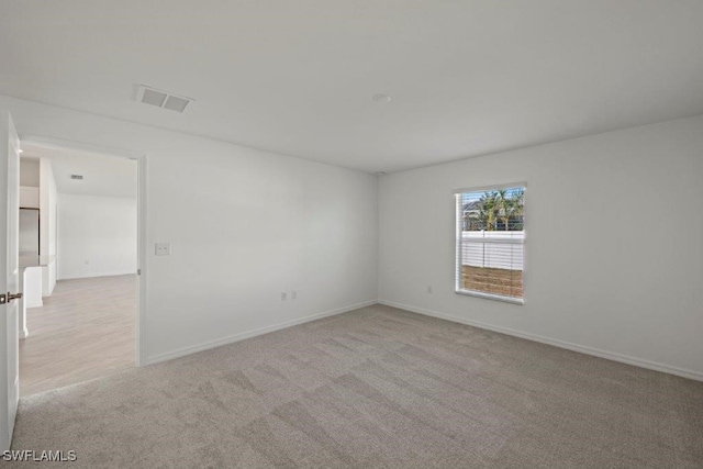 unfurnished room featuring light carpet, visible vents, and baseboards