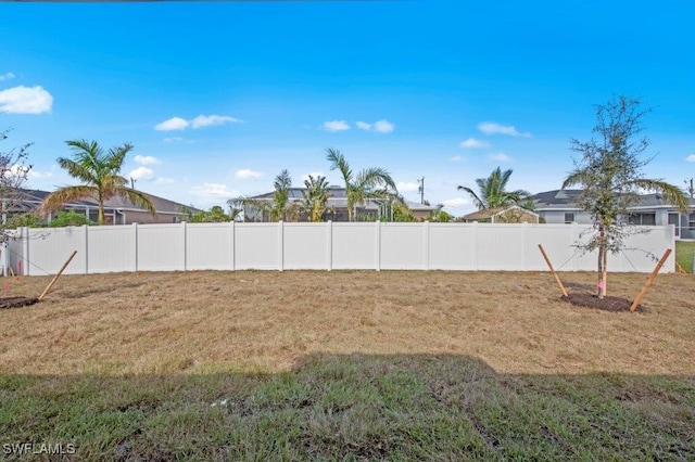 view of yard featuring a fenced backyard and a residential view