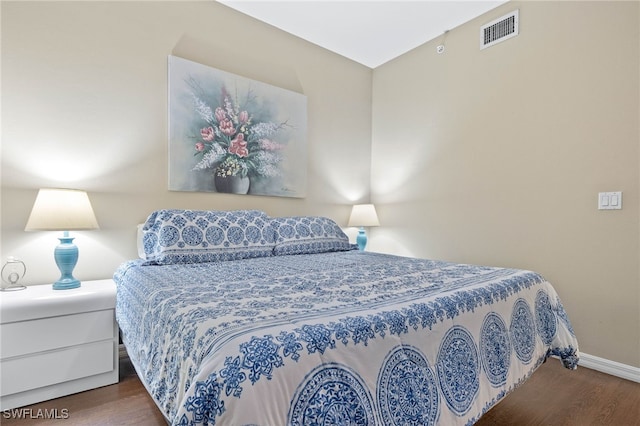 bedroom featuring dark wood finished floors, visible vents, and baseboards