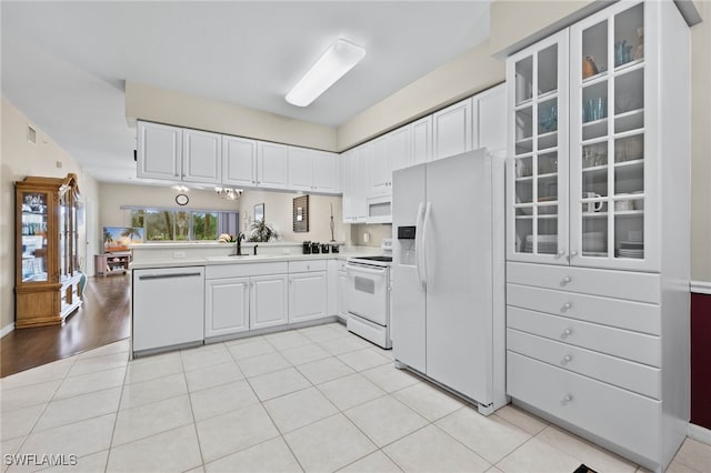 kitchen with light countertops, white appliances, glass insert cabinets, and white cabinetry