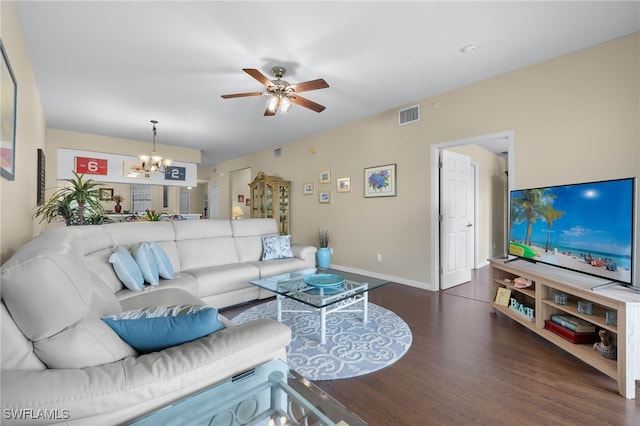 living room with ceiling fan with notable chandelier, dark wood-type flooring, visible vents, and baseboards