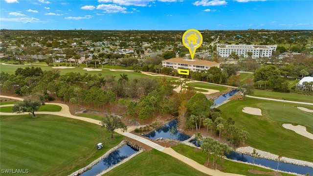 drone / aerial view with golf course view and a water view