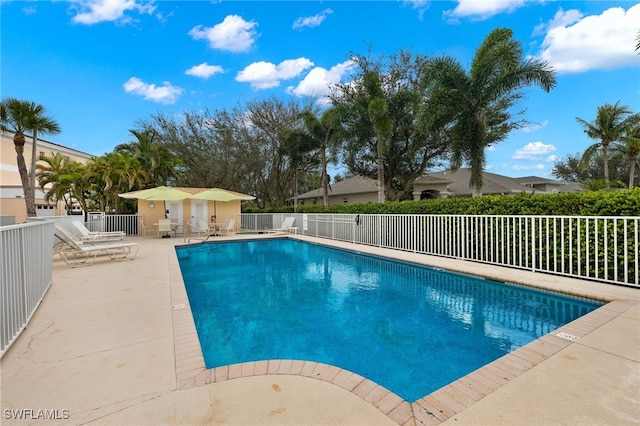 community pool with a patio and fence