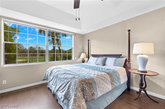 bedroom featuring dark wood-style flooring, a ceiling fan, and baseboards