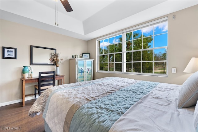 bedroom with ceiling fan, wood finished floors, and baseboards