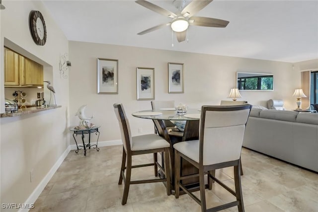 dining area with ceiling fan and baseboards