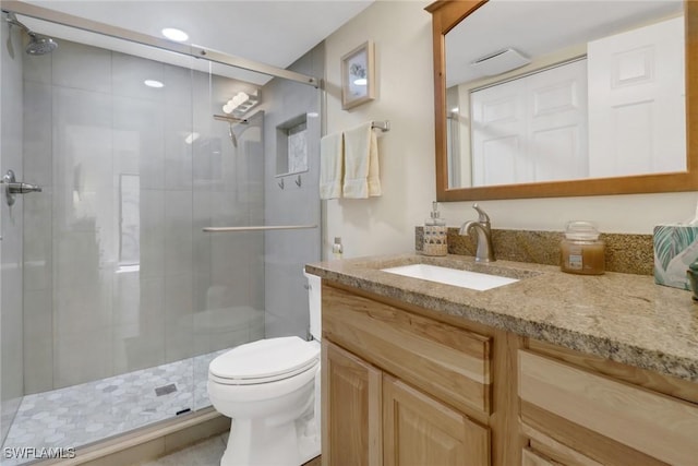 bathroom featuring a stall shower, vanity, and toilet