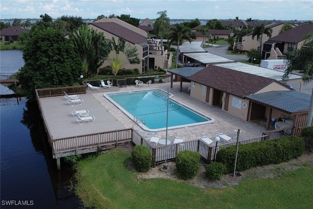 community pool with a residential view, a water view, a patio, and fence