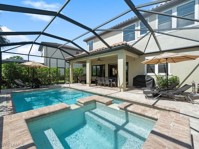 view of pool with glass enclosure, ceiling fan, a grill, a patio area, and a pool with connected hot tub