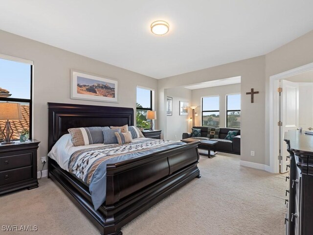 bedroom with light carpet and baseboards