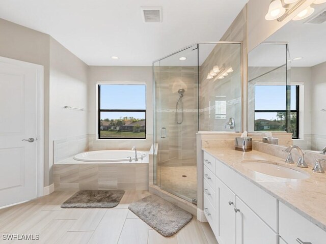 full bathroom with a stall shower, visible vents, a garden tub, and vanity