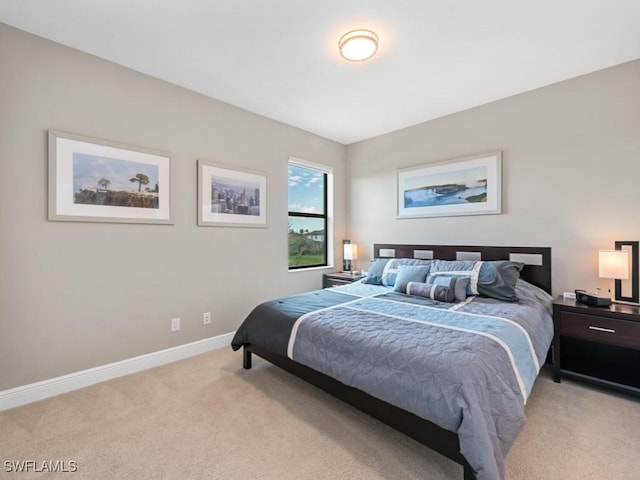 bedroom featuring light colored carpet and baseboards