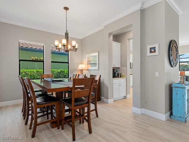 dining room featuring crown molding, light wood-style floors, baseboards, and a notable chandelier