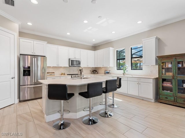 kitchen featuring a kitchen island with sink, visible vents, white cabinets, light countertops, and appliances with stainless steel finishes