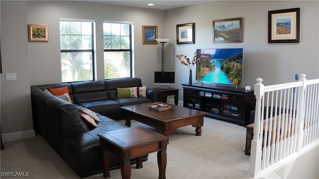 carpeted living area featuring baseboards