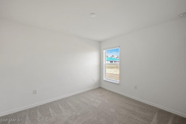 unfurnished room with carpet floors and baseboards