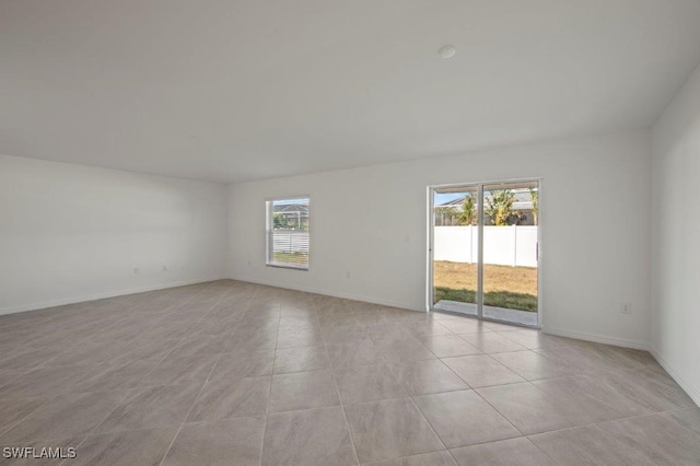 spare room with light tile patterned floors and baseboards