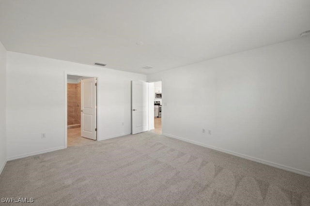 unfurnished bedroom featuring baseboards, visible vents, and light colored carpet