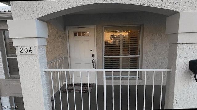 property entrance featuring stucco siding