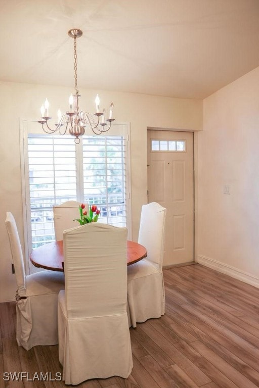 dining room featuring baseboards, a chandelier, and wood finished floors