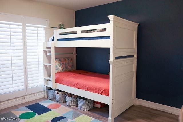 bedroom featuring baseboards and wood finished floors