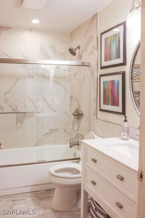 full bath with combined bath / shower with glass door, vanity, and toilet