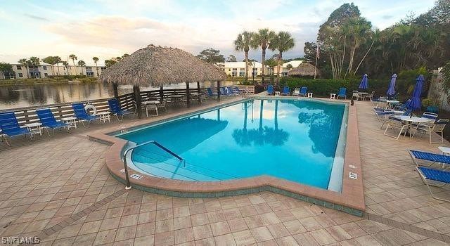 pool featuring a patio area, a water view, and a gazebo