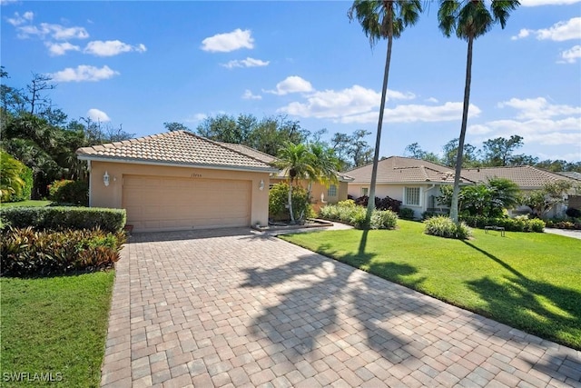 view of front of property featuring a garage, a tile roof, decorative driveway, stucco siding, and a front lawn