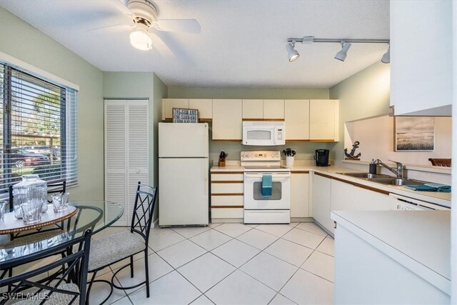 kitchen with light tile patterned floors, light countertops, a ceiling fan, a sink, and white appliances