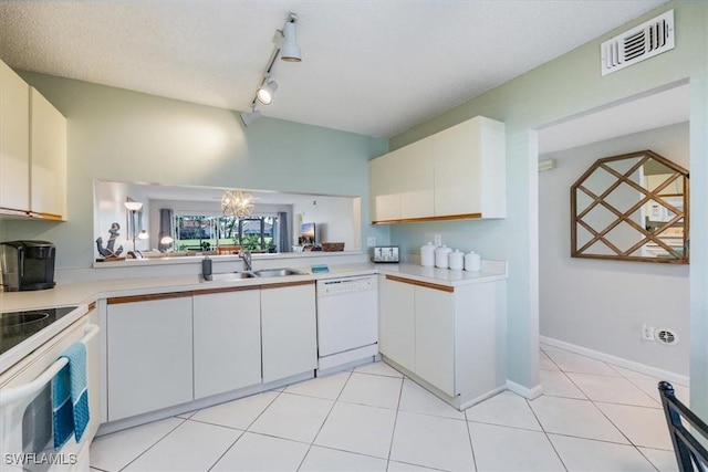 kitchen with light countertops, white appliances, a sink, and visible vents