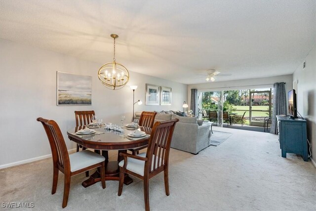 dining room with light colored carpet, visible vents, baseboards, and ceiling fan with notable chandelier