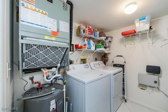 laundry area featuring light tile patterned floors, laundry area, water heater, and washer and clothes dryer