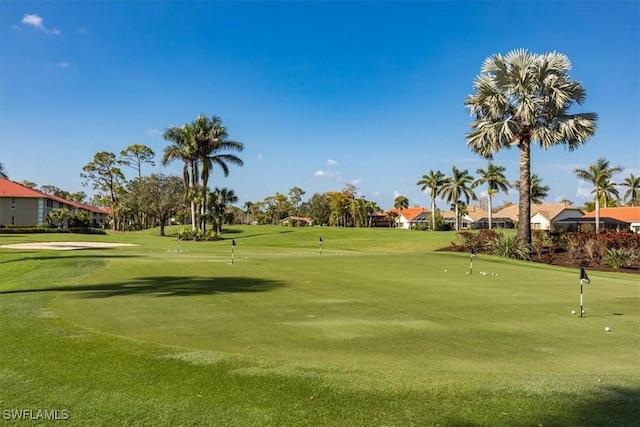 surrounding community with golf course view and a lawn