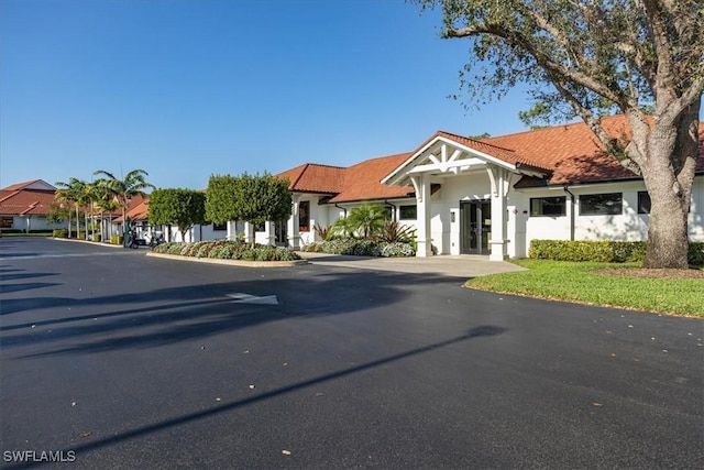 view of front of home featuring a tile roof, a residential view, and stucco siding