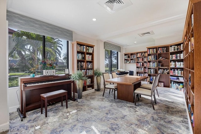 office space with wall of books, baseboards, visible vents, and crown molding