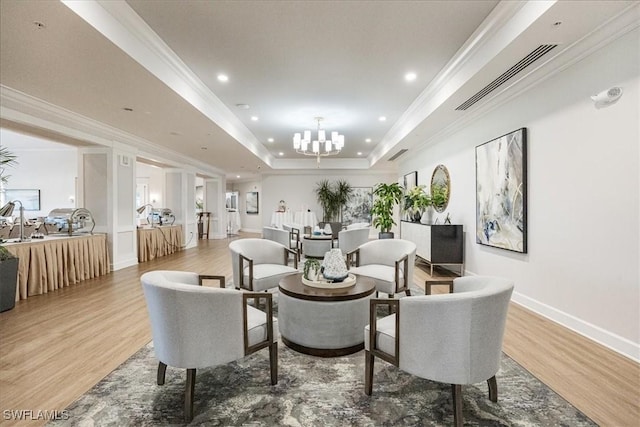 interior space with ornamental molding, a tray ceiling, visible vents, and light wood-style floors