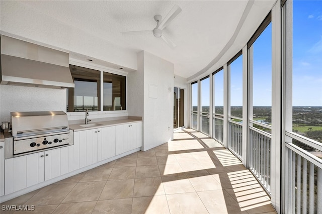 unfurnished sunroom with ceiling fan and a sink