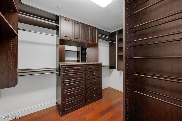 walk in closet with wood finished floors