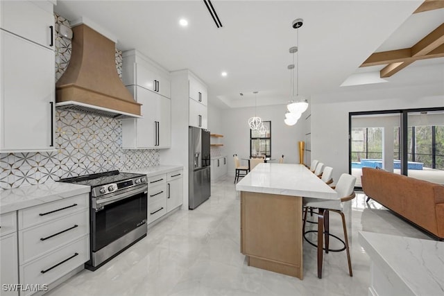 kitchen featuring pendant lighting, custom exhaust hood, stainless steel appliances, white cabinets, and a kitchen island