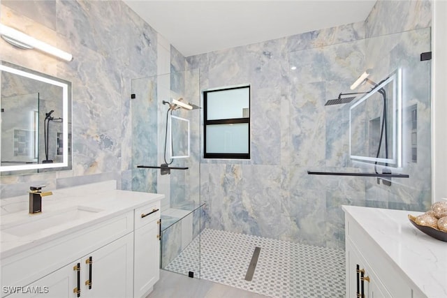 bathroom with vanity, tile walls, and a shower stall