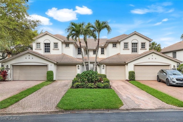 view of front of house with a tile roof, decorative driveway, and stucco siding