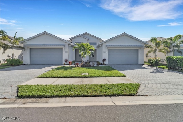 ranch-style home with a garage, decorative driveway, and a front yard