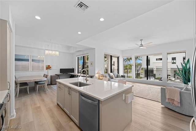 kitchen featuring light wood-type flooring, open floor plan, a sink, and stainless steel dishwasher