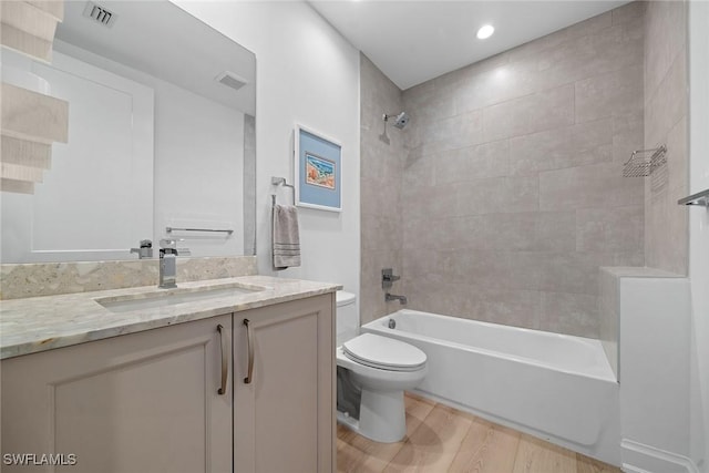 full bath featuring visible vents, vanity, toilet, and wood finished floors