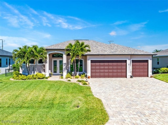 view of front of house with an attached garage, decorative driveway, french doors, a front lawn, and stucco siding