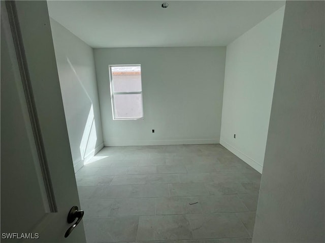 unfurnished room with baseboards