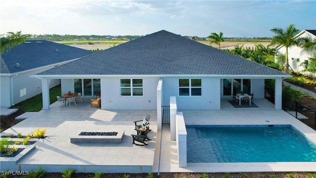 rear view of house with a patio, fence, a fire pit, and a fenced in pool