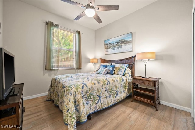 bedroom with ceiling fan, wood finished floors, and baseboards