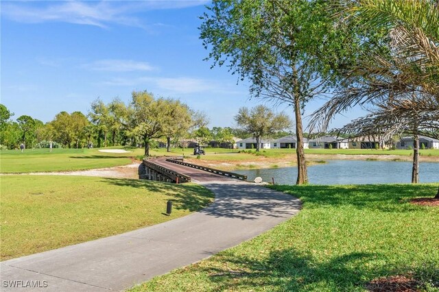 surrounding community with a water view and a yard